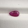 A 1.14-carat natural red ruby from Mozambique in a pear faceted cut, showing authentic natural surface pits and rich red color, displayed in a professional jeweler's box.