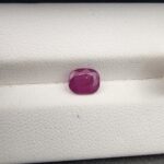 A 1.38-carat natural red ruby from Mozambique with a cushion faceted cut, showcasing intense red color and high clarity.