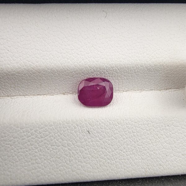 A 1.38-carat natural red ruby from Mozambique with a cushion faceted cut, showcasing intense red color and high clarity.