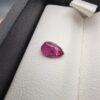 A 0.81-carat natural red ruby from Mozambique in a pear faceted cut, showing vibrant red color and an authentic natural surface pit, displayed in a professional jeweler's box.
