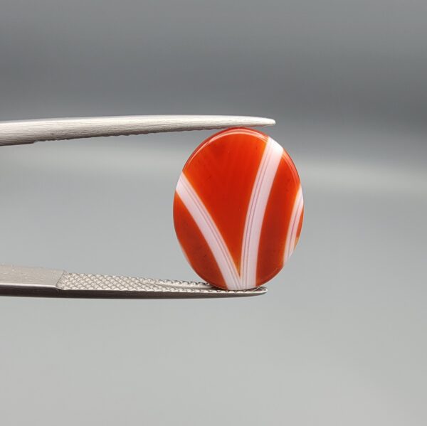A 9.32-carat natural orangish-red Aqeeq gemstone with a prominent horizontal white band, presented in a professional jeweler's box.