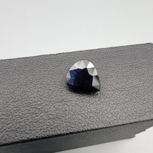 A 3.67-carat natural blue sapphire from Kanchanaburi, Thailand, featuring a deep blue color and a pear faceted cut, displayed in a white jeweler's box.