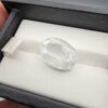 A massive 14.78-carat natural white sapphire from Sri Lanka, featuring a brilliant colorless clarity and masterful faceted cut, presented in a luxury jeweler's display box.