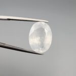 A massive 14.78-carat natural white sapphire from Sri Lanka, featuring a brilliant colorless clarity and masterful faceted cut, presented in a luxury jeweler's display box.