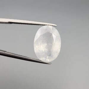 A massive 14.78-carat natural white sapphire from Sri Lanka, featuring a brilliant colorless clarity and masterful faceted cut, presented in a luxury jeweler's display box.