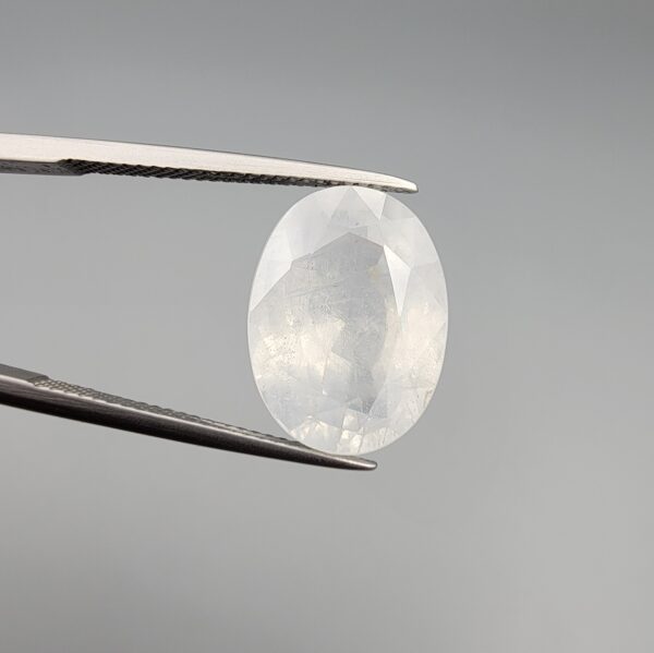 A massive 14.78-carat natural white sapphire from Sri Lanka, featuring a brilliant colorless clarity and masterful faceted cut, presented in a luxury jeweler's display box.