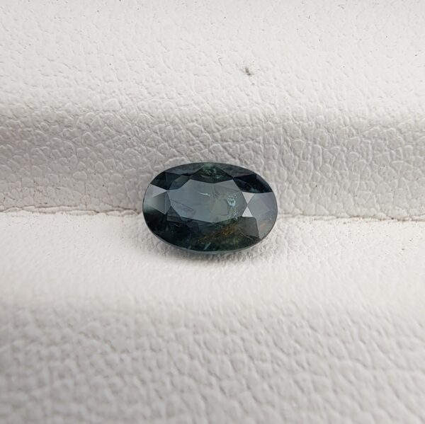 A 0.99-carat natural teal blue sapphire from Kanchanaburi, Thailand, with an oval faceted cut and a saturated blue-green color, presented in a professional jeweler's box