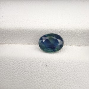 A large 2.06-carat natural teal blue sapphire from Kanchanaburi, Thailand, featuring a masterfully faceted oval cut and deep blue-green saturation, shown in a professional white jeweler's box.