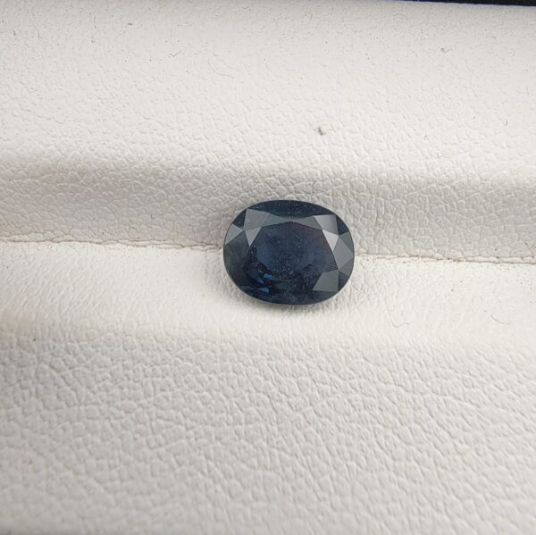 A 1.76-carat natural blue sapphire from Kanchanaburi, Thailand, featuring an oval faceted cut and deep royal blue saturation, presented in a professional jeweler's box.