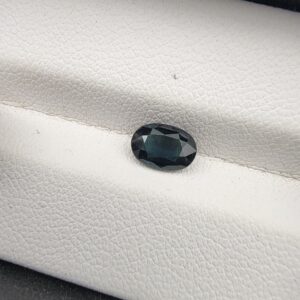 A 1.01-carat natural blue sapphire from Kanchanaburi, Thailand, featuring a masterfully faceted oval cut and deep royal blue color, presented in a professional white jeweler's box.