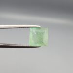 A natural 2.53-carat mint green emerald from Chithral Valley, Pakistan, featuring an octagon step cut with visible natural inclusions, held in professional jeweler's tweezers.