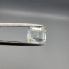 A natural 2.28-carat pale blue aquamarine from Shigar Valley, Pakistan, featuring an octagon step cut with visible natural internal veining and inclusions, held in professional jeweler's tweezers.