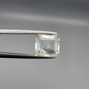 A natural 2.28-carat pale blue aquamarine from Shigar Valley, Pakistan, featuring an octagon step cut with visible natural internal veining and inclusions, held in professional jeweler's tweezers.