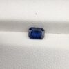 A natural 0.96-carat blue sapphire (Neelam) from Ceylon, Sri Lanka, featuring a faceted oval cut with rich cornflower blue color and high clarity, held securely in professional jeweler's tweezers.