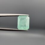 A natural 4.00-carat green emerald from the Chitral Valley, Pakistan, featuring a well-proportioned octagon step cut and classic green saturation with natural internal inclusions, held securely in professional jeweler's tweezers.