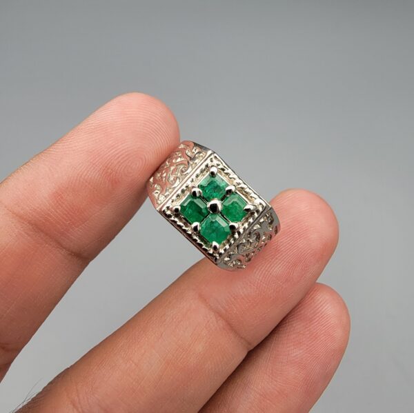 ​A handcrafted men's 925 sterling silver ring showcasing a vertical channel layout of 4 natural Swat Valley emeralds with a rich alpine green color profile, displayed from multiple professional angles on a reflective surface.