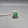 ​A handcrafted men's 925 sterling silver ring showcasing a vertical channel layout of 4 natural Swat Valley emeralds with a rich alpine green color profile, displayed from multiple professional angles on a reflective surface.