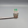 ​A handcrafted men's 925 sterling silver ring showcasing a vertical channel layout of 4 natural Swat Valley emeralds with a rich alpine green color profile, displayed from multiple professional angles on a reflective surface.