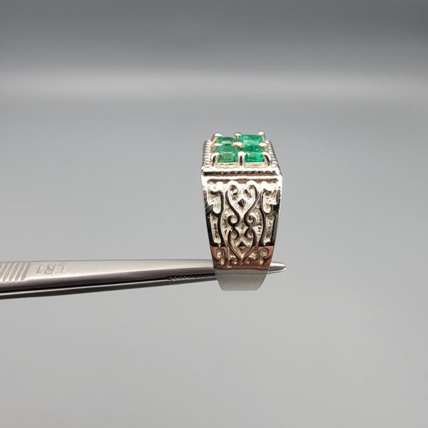 ​A handcrafted men's 925 sterling silver ring showcasing a vertical channel layout of 4 natural Swat Valley emeralds with a rich alpine green color profile, displayed from multiple professional angles on a reflective surface.