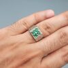 ​A handcrafted men's 925 sterling silver ring showcasing a vertical channel layout of 4 natural Swat Valley emeralds with a rich alpine green color profile, displayed from multiple professional angles on a reflective surface.