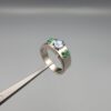​A premium handcrafted men's 925 sterling silver ring featuring a large oval-cut natural Ceylon blue sapphire center stone flanked by two vibrant, square-cut Swat Valley emerald side stones, displayed on a clean reflective surface.