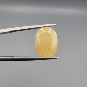 Official Galaxy Gemological Institute (GGI) Gemstone Report for a 6.25-carat Natural Yellow Sapphire. The certificate lists report number KHI260609001 and displays a digital product image of the loose, oval-cut semi-transparent stone resting on a white reflective surface, emphasizing its bright, sun-kissed yellow tone and prominent mixed faceting architecture.