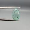 ​A 2.06-carat natural Colombian Emerald gemstone held vertically in professional metal gemstone tweezers against a smooth gray studio background. The loose gem is fashioned into a graceful pear shape, displaying a highly authentic, transparent mint-to-forest green core filled with dense, raw internal mountain fissures, natural inclusions, and soft organic mineral cracks.