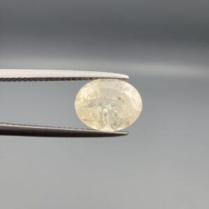 A premium, high-clarity 2.67-carat natural Ceylon Yellow Sapphire gemstone held horizontally in professional steel gemstone tweezers against a smooth gray studio background. The loose Sri Lankan Pukhraj features an elegant faceted oval cut, displaying a vibrant, evenly distributed lemon-yellow color profile with immaculate crown facet symmetry and intense internal light refraction.