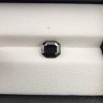 An official authenticity identification card from the Jaipur Gemological Lab for Specimen No. 5370144, verifying a 1.29-carat Natural Black Diamond. The lab certificate displays full technical details, including measurements of 7.20 x 2.87 mm, an octagon shape, a Mohs hardness of 10, and a small photographic insert showing the faceted rectangular black diamond.