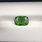 A premium, high-brilliance 2.97-carat natural Vivid Green Tourmaline gemstone from Madagascar resting elegantly inside a white leather-textured luxury display box. The loose gem showcases a masterfully faceted cushion cut with excellent edge symmetry, displaying an intensely vibrant, rich green color saturation paired with breathtaking internal sparkle and light performance.
