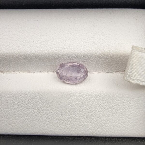 A premium, high-clarity 1.84-carat natural Ceylon Light Purple Sapphire gemstone nestled securely in a luxury white-cushioned black display box. The loose gem showcases an elegant faceted oval cut, displaying a delicate, brightly saturated light violet-purple body color with excellent internal light refraction and pristine facet symmetry.