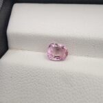 A rare, high-clarity 1.06-carat natural Ceylon Pink Sapphire gemstone presented from multiple angles on a luxury white-cushioned display surface. The loose gem showcases an elegant faceted cushion cut with beautifully soft edges, displaying an intensely vibrant pink body color with pristine facet symmetry, zero enhancements, and exceptional internal light reflection.