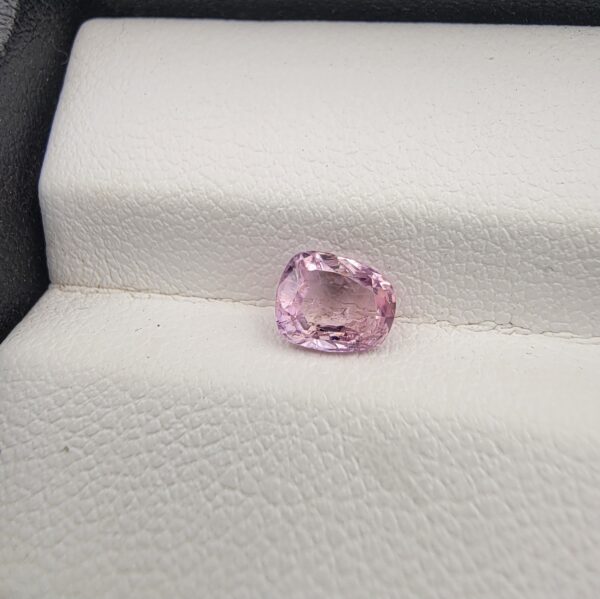 A rare, high-clarity 1.06-carat natural Ceylon Pink Sapphire gemstone presented from multiple angles on a luxury white-cushioned display surface. The loose gem showcases an elegant faceted cushion cut with beautifully soft edges, displaying an intensely vibrant pink body color with pristine facet symmetry, zero enhancements, and exceptional internal light reflection.
