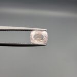 a premium, high-translucency 1.81-carat natural Ceylon Light Pink Sapphire gemstone is held securely in metal tweezers against a clean, neutral grey background. The loose gem showcases an elegant faceted cushion cut with beautifully sharp facet junctions, displaying a delicate, softly translucent pastel pink body color with pristine facet symmetry, zero enhancements, and fine internal natural inclusions that verify its entirely untreated origin.