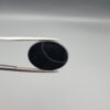 "Natural Black Sulemani Aqeeq Agate oval cabochon gemstone 15.30 carat with white eye ring pattern held in tweezers"