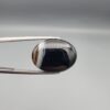 "Natural Black Banded Sulemani Aqeeq Agate oval cabochon gemstone 14.00 carat with white side banding held in tweezers"