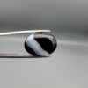 "Natural Black Banded Sulemani Aqeeq Agate oval cabochon gemstone 14.27 carat with curved white and brown band held in tweezers"