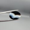 "Natural Black Banded Sulemani Aqeeq Agate oval cabochon gemstone 14.03 carat with horizontal white and brown wave band held in tweezers"