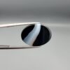 "Natural Black Banded Sulemani Aqeeq Agate oval cabochon gemstone 15.15 carat with diagonal white and brown swirl band held in tweezers"