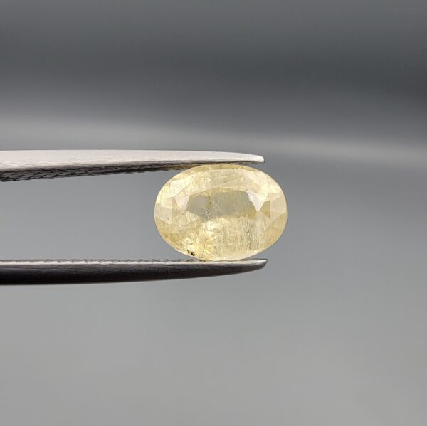 "Natural unheated Yellow Sapphire Pukhraj gemstone 2.13 carat cushion cut from Sri Lanka Ceylon held in tweezers showing silky natural inclusions"
