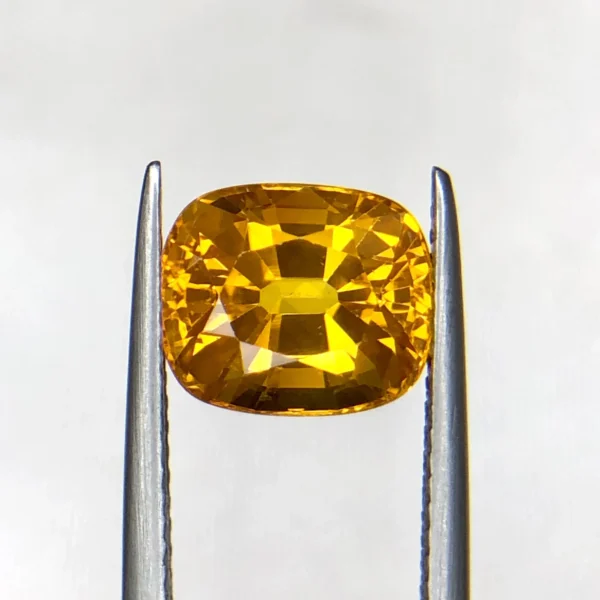 High-resolution photograph of an official Galaxy Gemological Institute (GGI) Gemstone Report certificate (No. KHI2609940326) dated 14 September 2026 for a 4.45-carat transparent Orangish Yellow natural cushion mixed-cut Yellow Sapphire from Madagascar.
