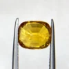High-resolution photograph of an official Galaxy Gemological Institute (GGI) Gemstone Report certificate (No. KHI2609940326) dated 14 September 2026 for a 4.45-carat transparent Orangish Yellow natural cushion mixed-cut Yellow Sapphire from Madagascar.
