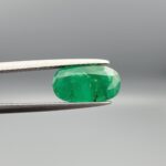 "Natural Emerald Panna Zamrud gemstone 2.35 carat oval cut from Swat Valley Pakistan held in tweezers showing rich green color and natural jardin inclusions"