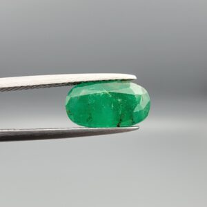 "Natural Emerald Panna Zamrud gemstone 2.35 carat oval cut from Swat Valley Pakistan held in tweezers showing rich green color and natural jardin inclusions"
