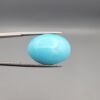 "Natural Razaki Feroza Turquoise gemstone 20.67 carat oval cabochon from Iran, front smooth sky-blue face and back natural matrix view, held in tweezers"