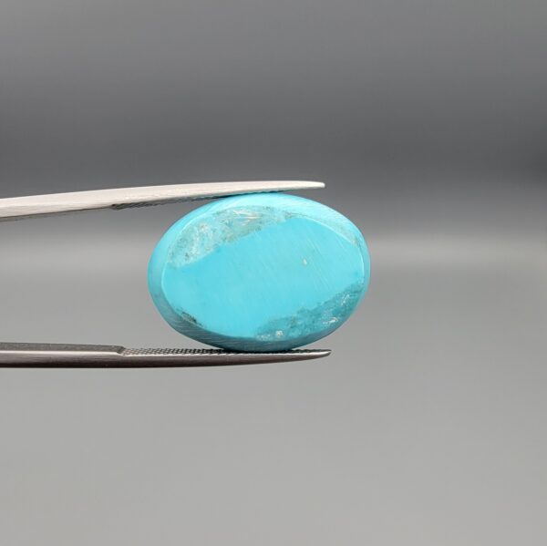"Natural Razaki Feroza Turquoise gemstone 20.67 carat oval cabochon from Iran, front smooth sky-blue face and back natural matrix view, held in tweezers"