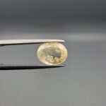 "Natural unheated Yellow Sapphire Pukhraj gemstone 2.88 carat oval cut from Sri Lanka Ceylon held in tweezers showing pale golden color and natural feather inclusions"