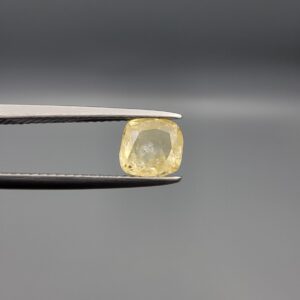 "Natural unheated Yellow Sapphire Pukhraj gemstone 1.66 carat cushion cut from Sri Lanka Ceylon held in tweezers showing pale golden color and natural inclusions"