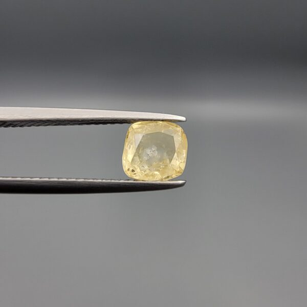 "Natural unheated Yellow Sapphire Pukhraj gemstone 1.66 carat cushion cut from Sri Lanka Ceylon held in tweezers showing pale golden color and natural inclusions"