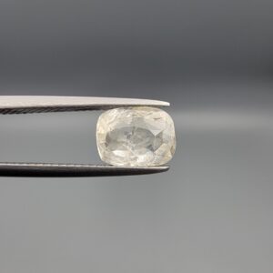 "Natural unheated Yellow Sapphire Pukhraj gemstone 2.35 carat cushion cut from Sri Lanka Ceylon held in tweezers showing near-white color and natural crystal inclusions"